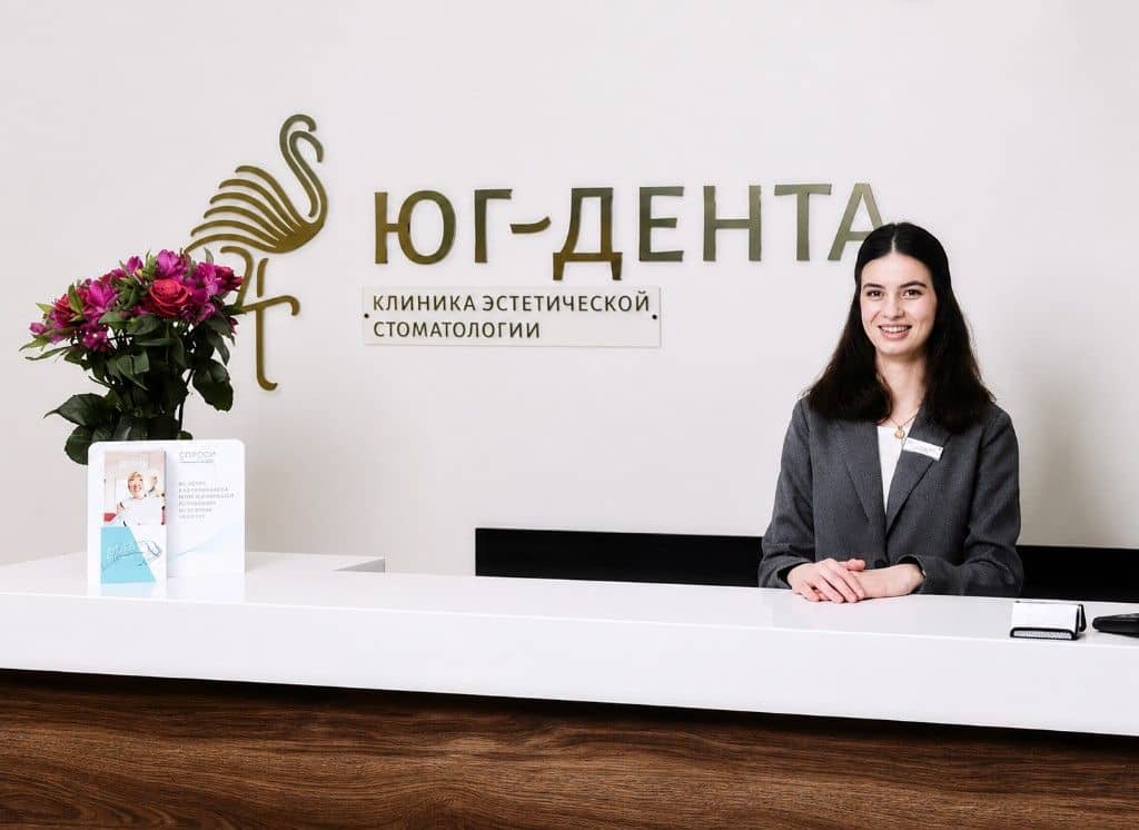 Администратор за стойкой ресепшена клиники Юг-Дента в Адлере